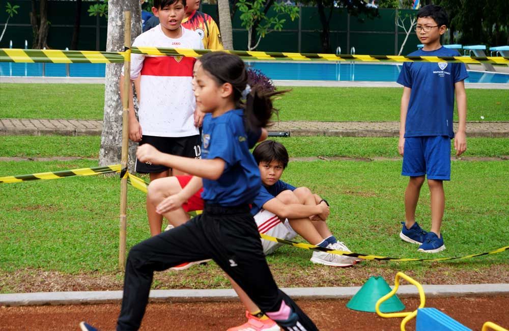 A group of children are playing a game on a track.