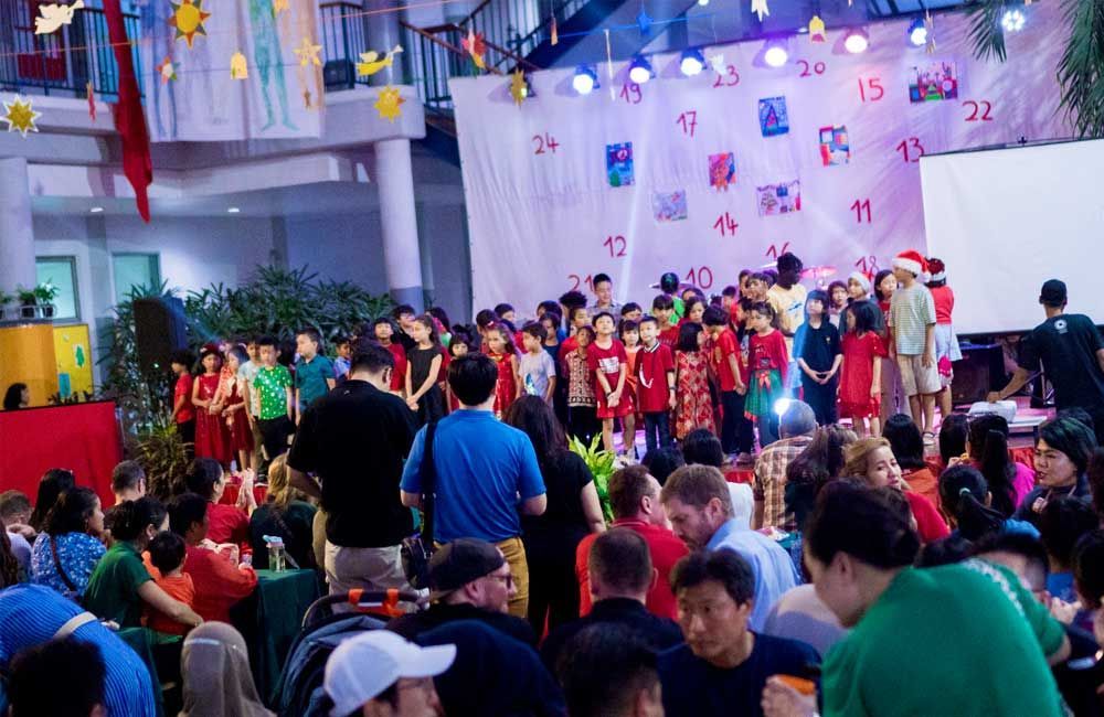 A large group of people are gathered in a room at a christmas party.
