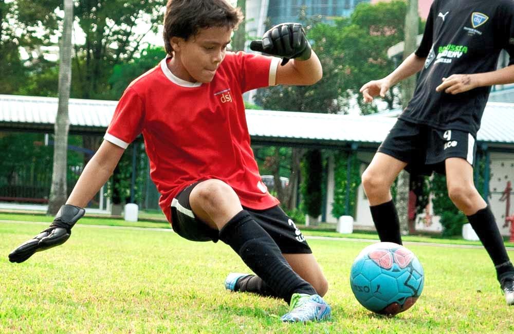 Two young boys are playing soccer on a field.