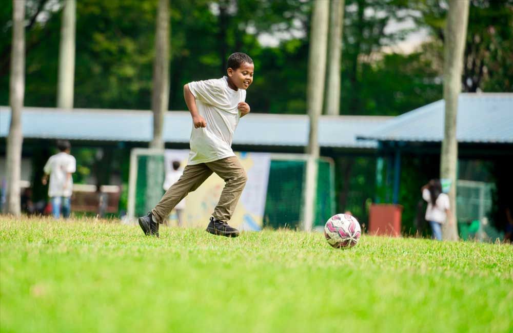A young boy is kicking a soccer ball on a field.