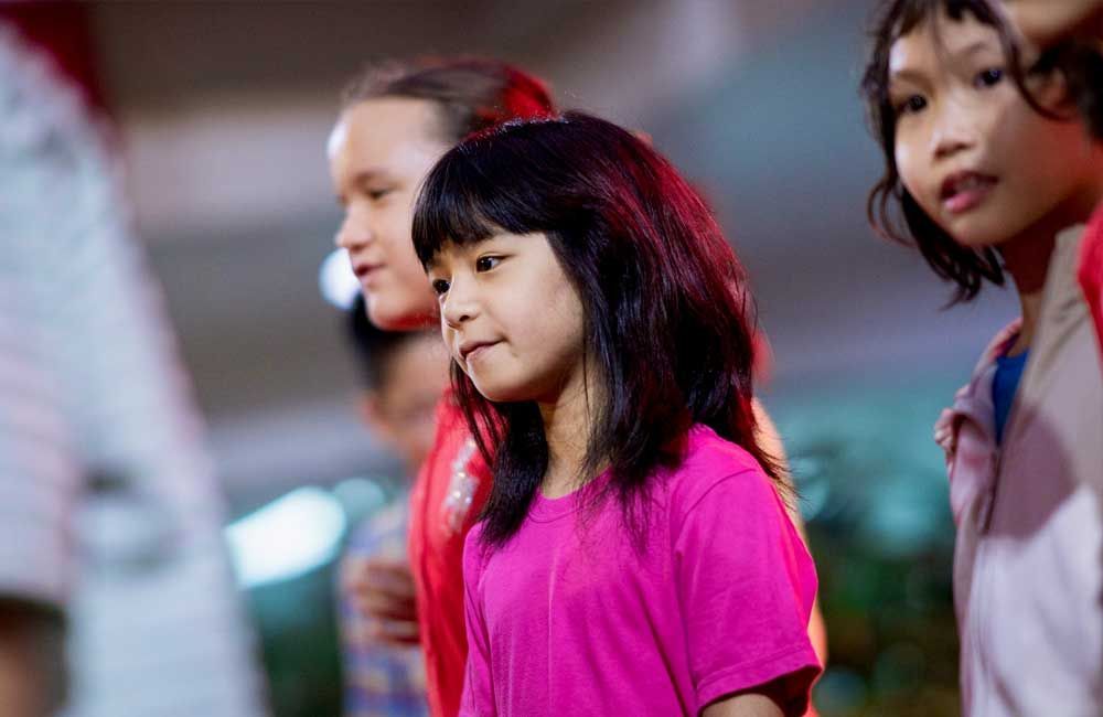 A group of young girls are standing next to each other in a room.