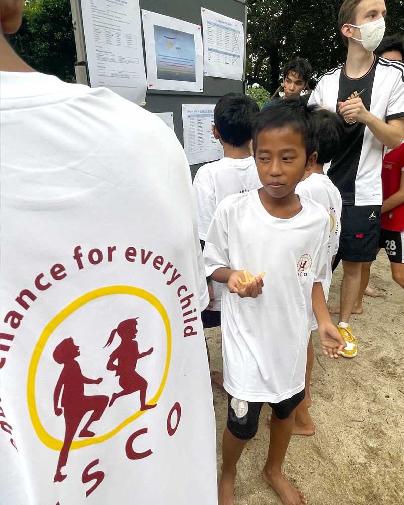 A boy wearing a white shirt that says alliance for every child