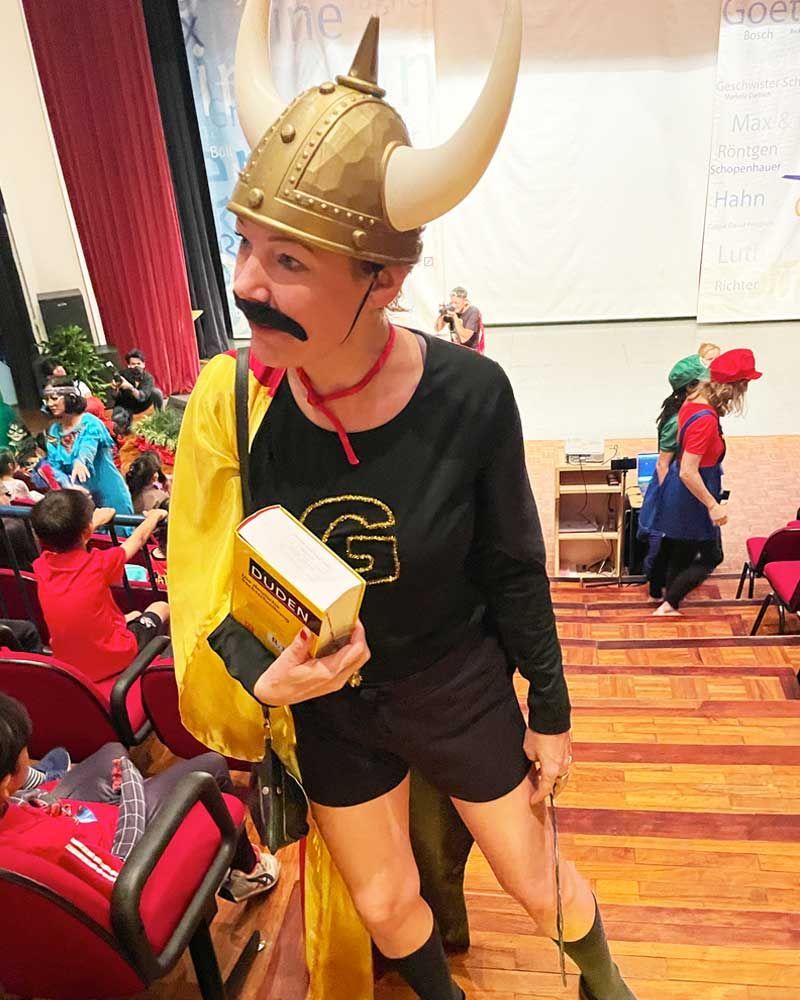A woman in a viking costume is holding a book