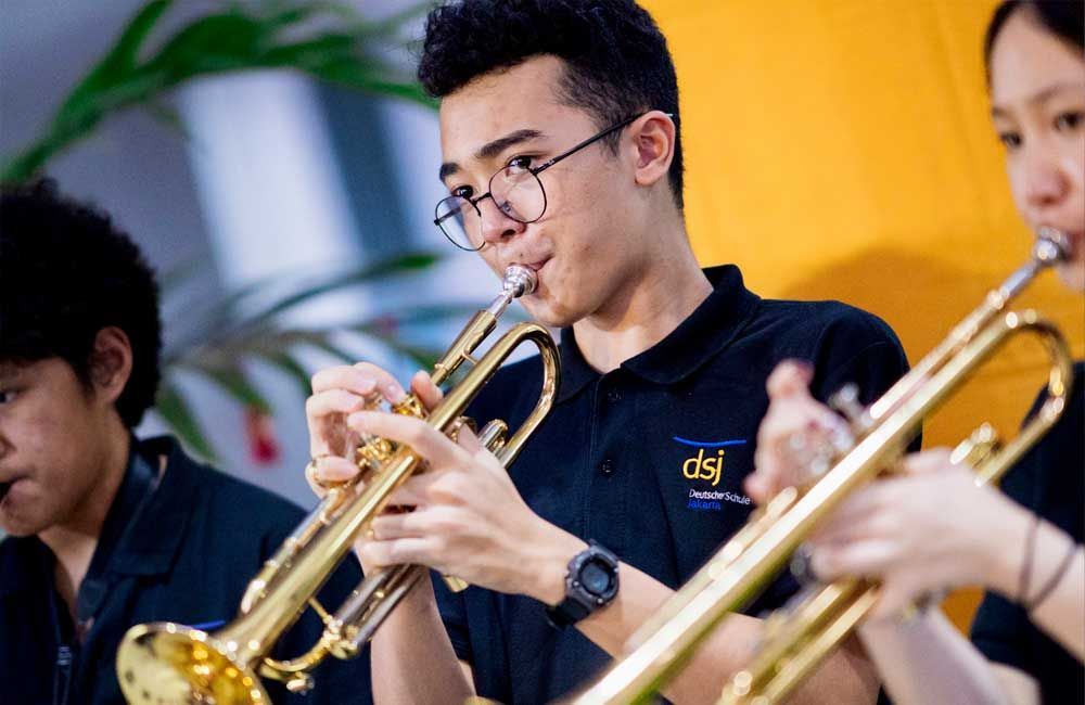 A man is playing a trumpet in a band.