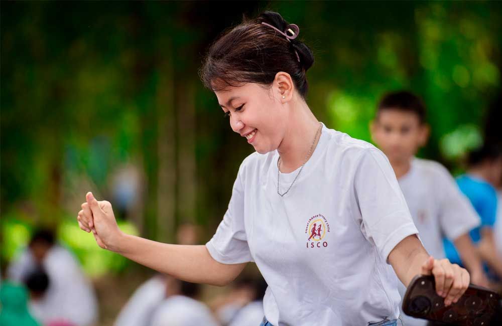 A young girl in a white shirt is dancing in a park.