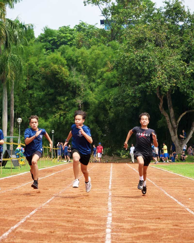 A group of young boys are running on a track.
