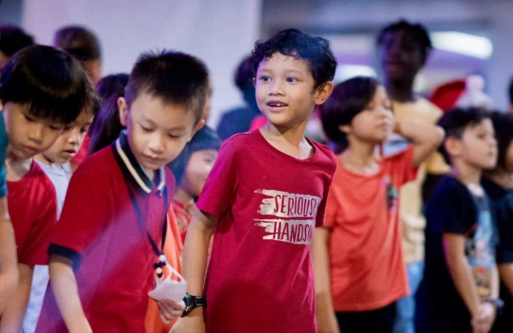 A group of young boys are standing next to each other in a room.