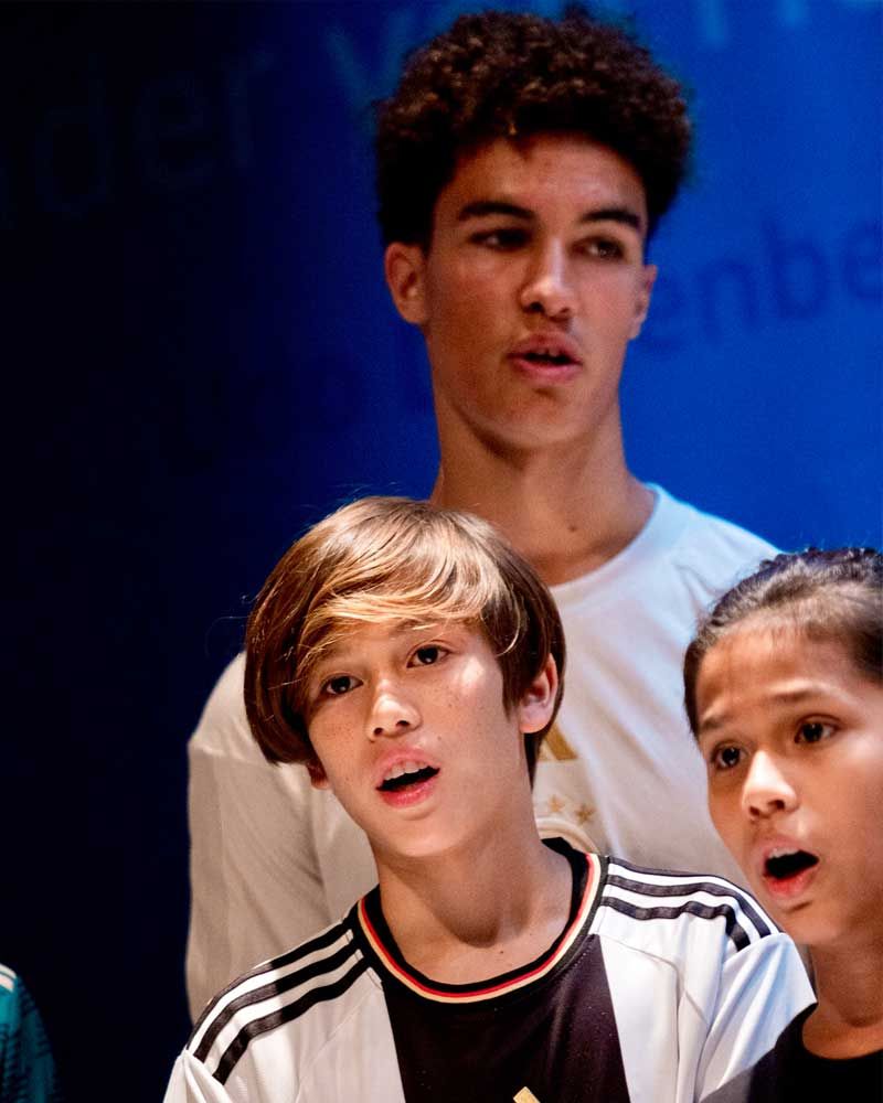A group of young people standing in front of a blue background