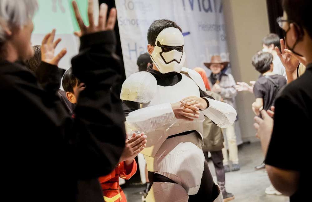 A man in a storm trooper costume is standing in a crowd of people.