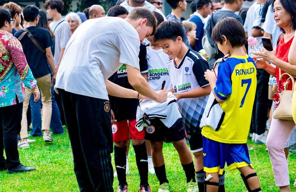 A group of young boys are standing on a soccer field.
