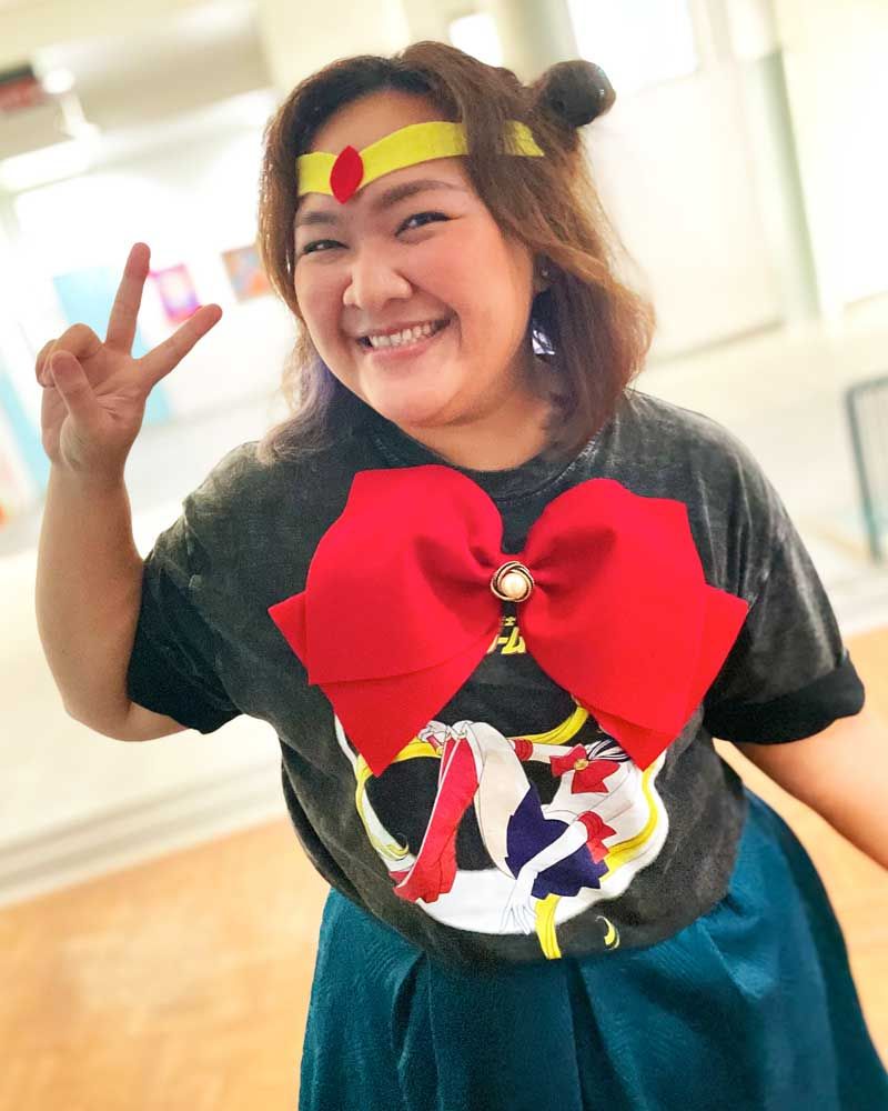 A woman in a sailor moon costume is giving a peace sign