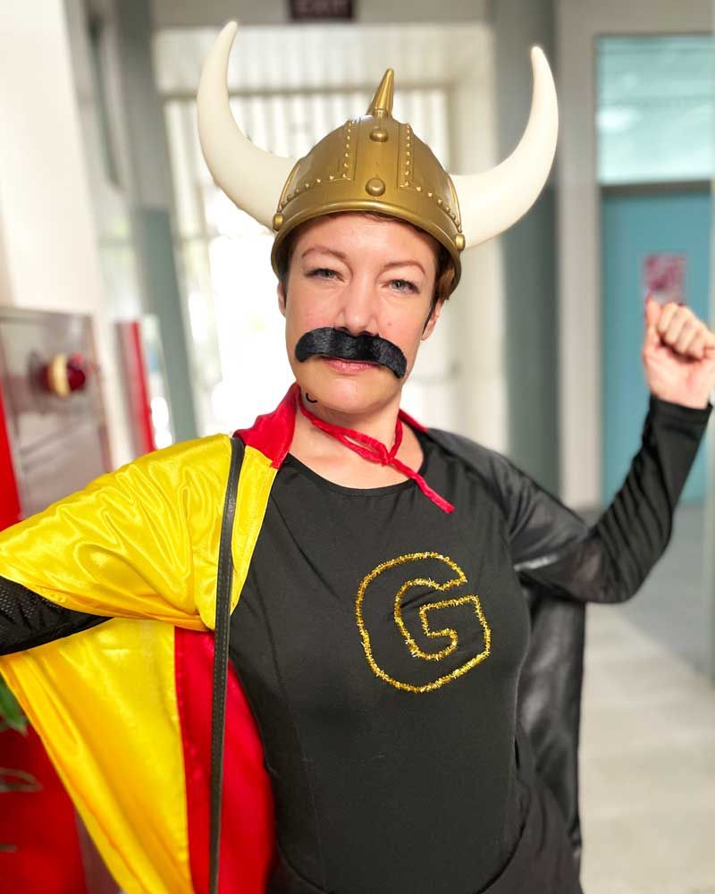 A woman in a viking costume with a g on her shirt