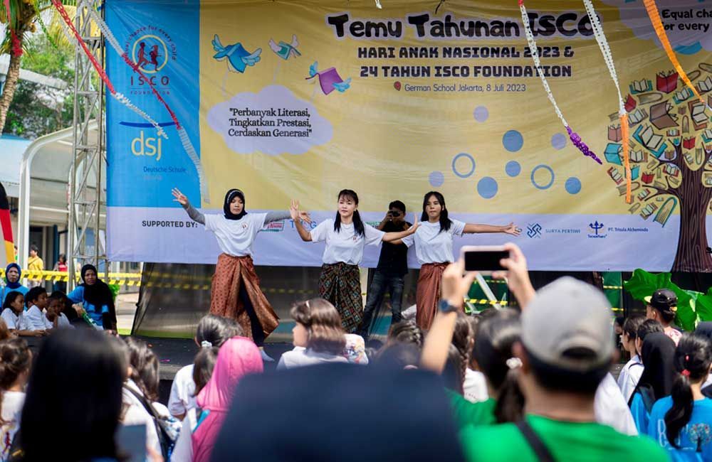 A group of people are dancing on a stage in front of a crowd.