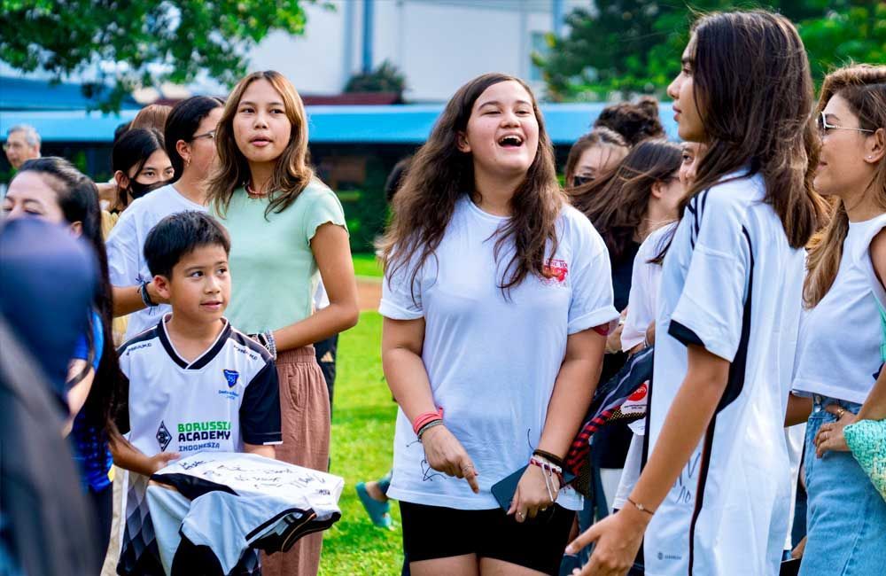 A group of young people are standing in a park.