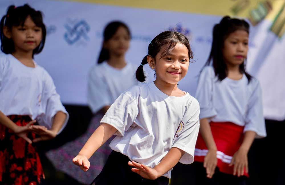 A group of young girls are performing a dance on stage.