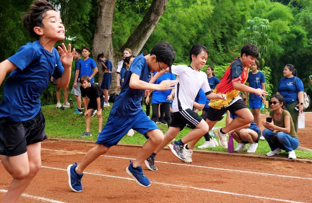 A group of young boys are running on a track.