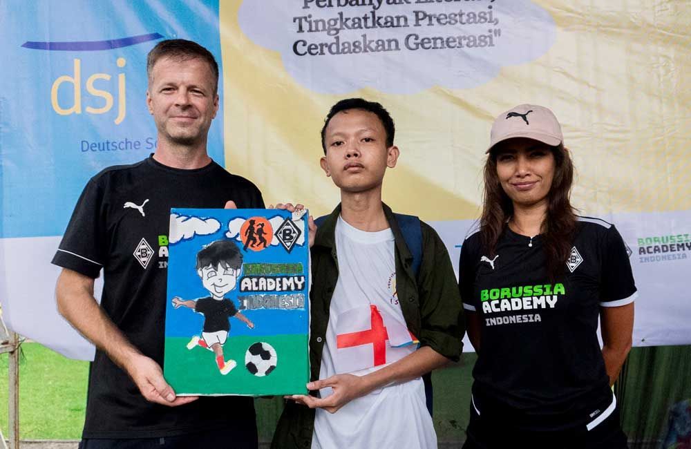 A group of people standing next to each other holding a sign that says academy