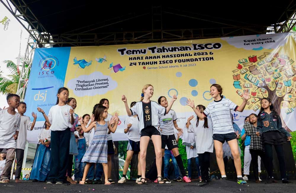 A group of children are dancing on a stage.