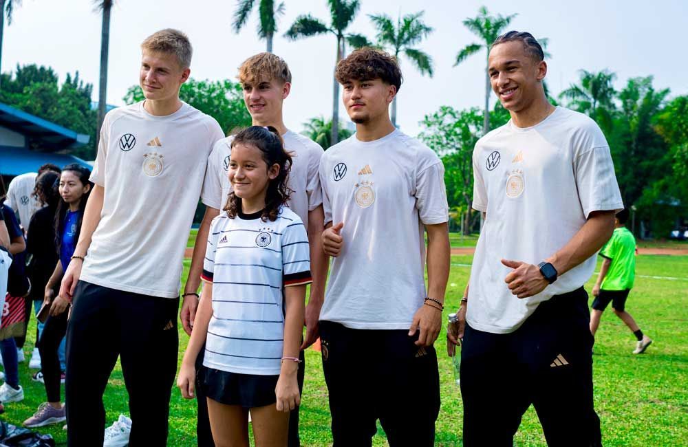 A group of young people standing next to each other on a field.