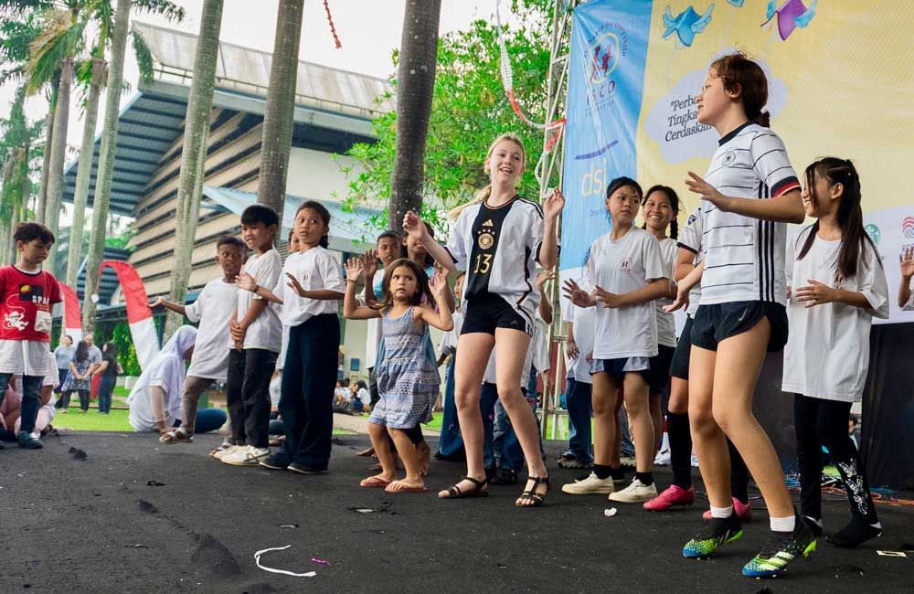 A group of children are dancing on a stage.