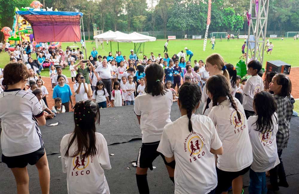 A group of young girls are dancing in front of a crowd.