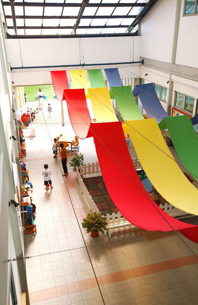 A building with a lot of colorful flags hanging from the ceiling