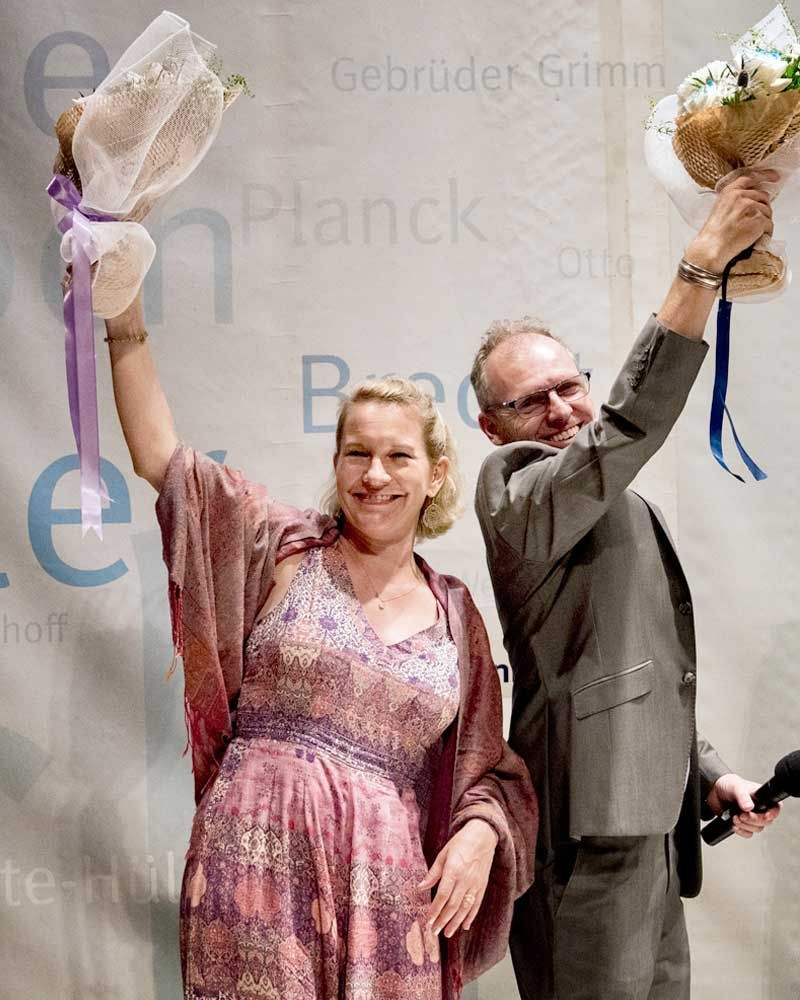 A man and a woman are holding flowers in their hands