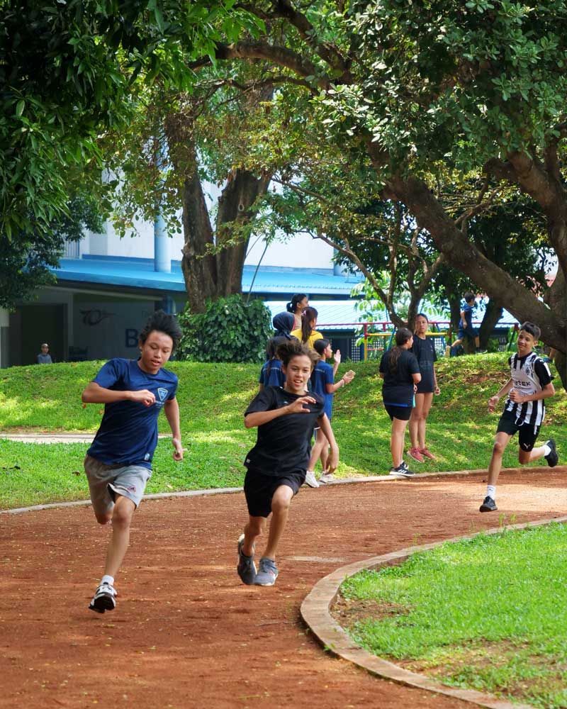 A group of people are running on a track in a park
