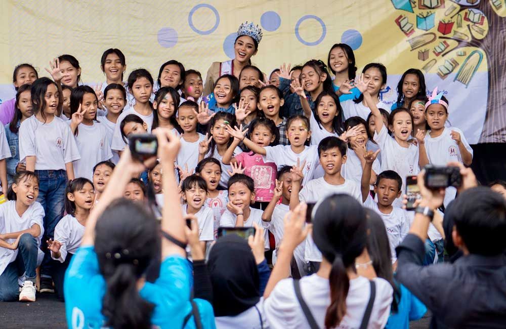 A group of children are posing for a picture while people take pictures of them.