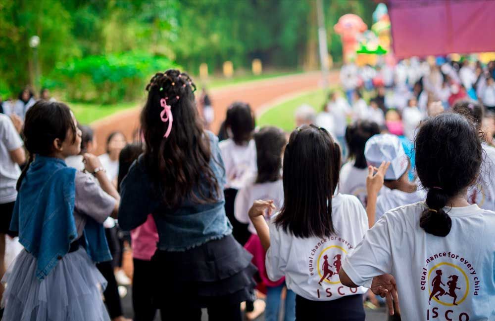 A group of children are dancing in a park.