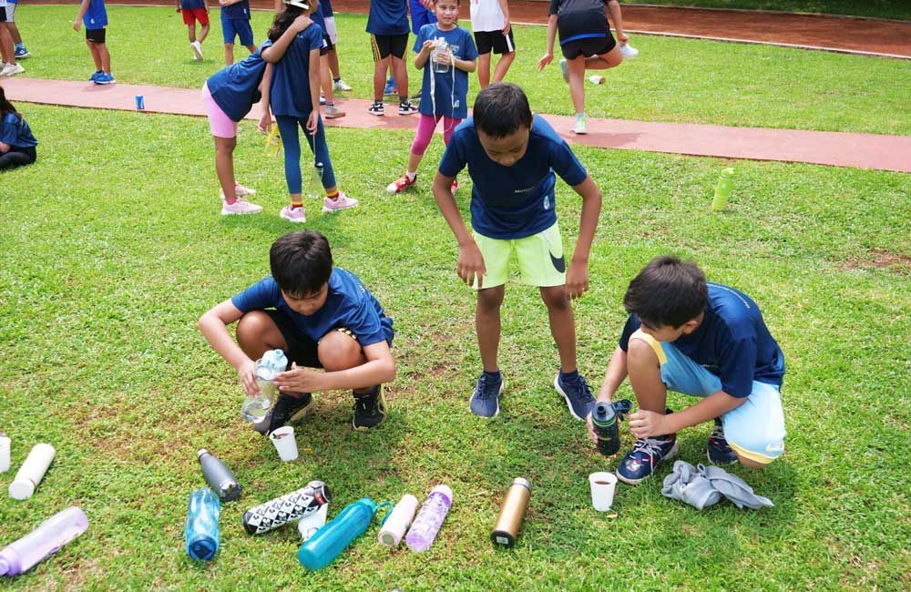 A group of children are playing a game on a lush green field.