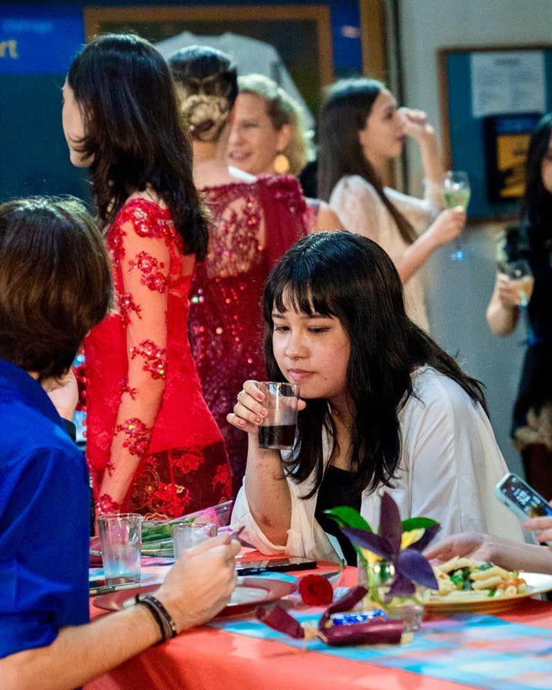 A group of people are sitting at a table drinking wine