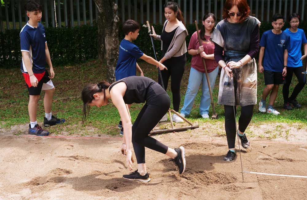 A group of people are playing a game on a dirt field.