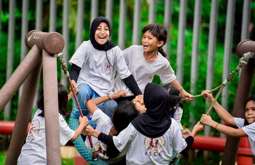 A group of children are playing on a swing set.