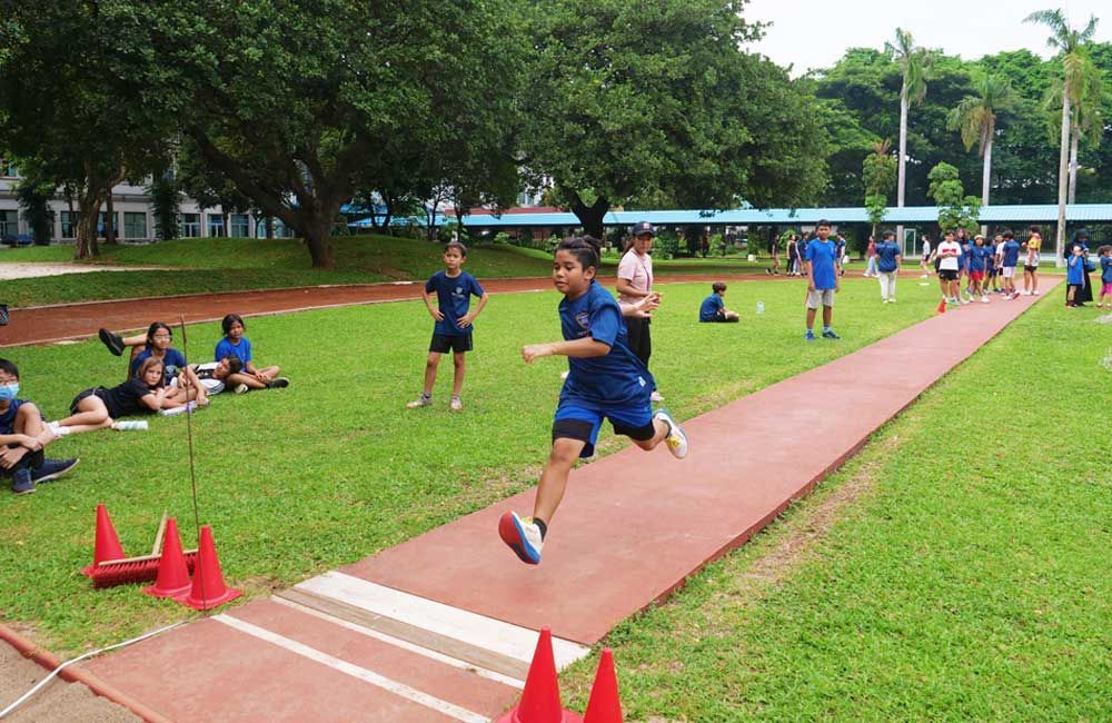 A group of children are running on a track in a park.