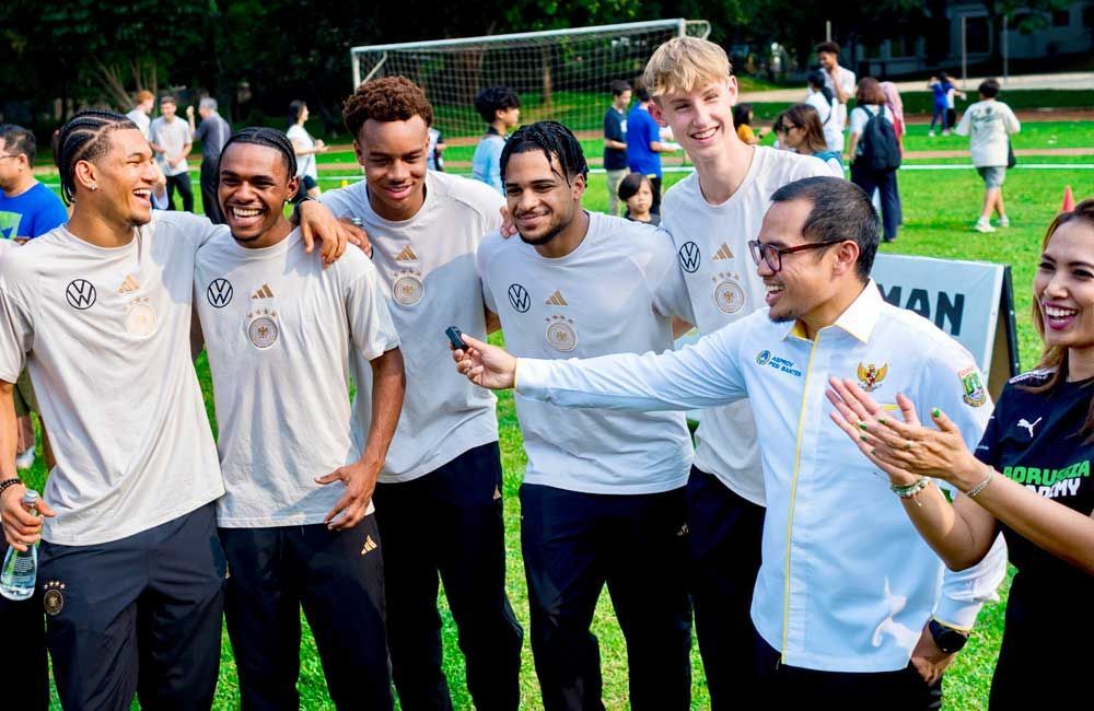 A group of people are posing for a picture on a soccer field.