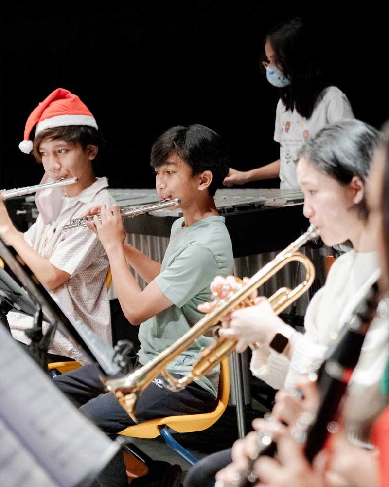 A group of children are playing instruments in an orchestra.