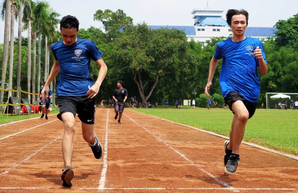 Two men are running on a track in a race.