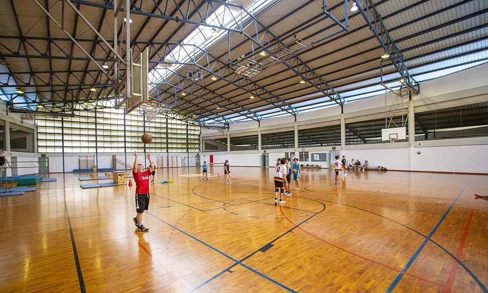 A group of people are playing basketball in a gym.