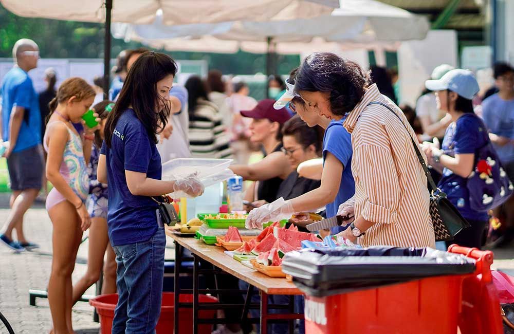 A group of people are standing around a table at a festival.