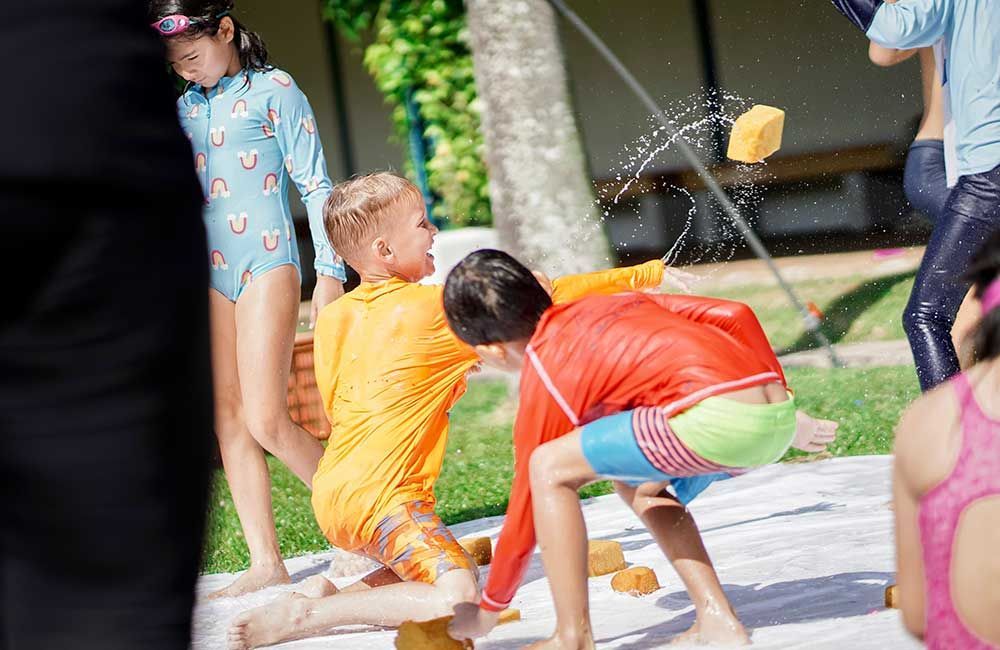 A group of children are playing with a water slide.