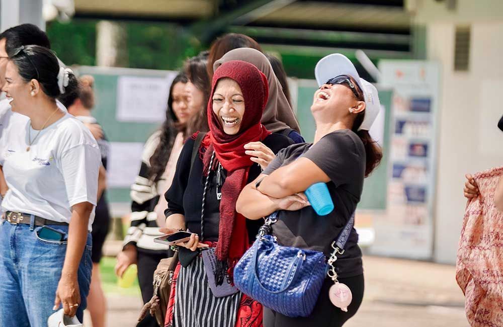 A group of women are standing next to each other and laughing.