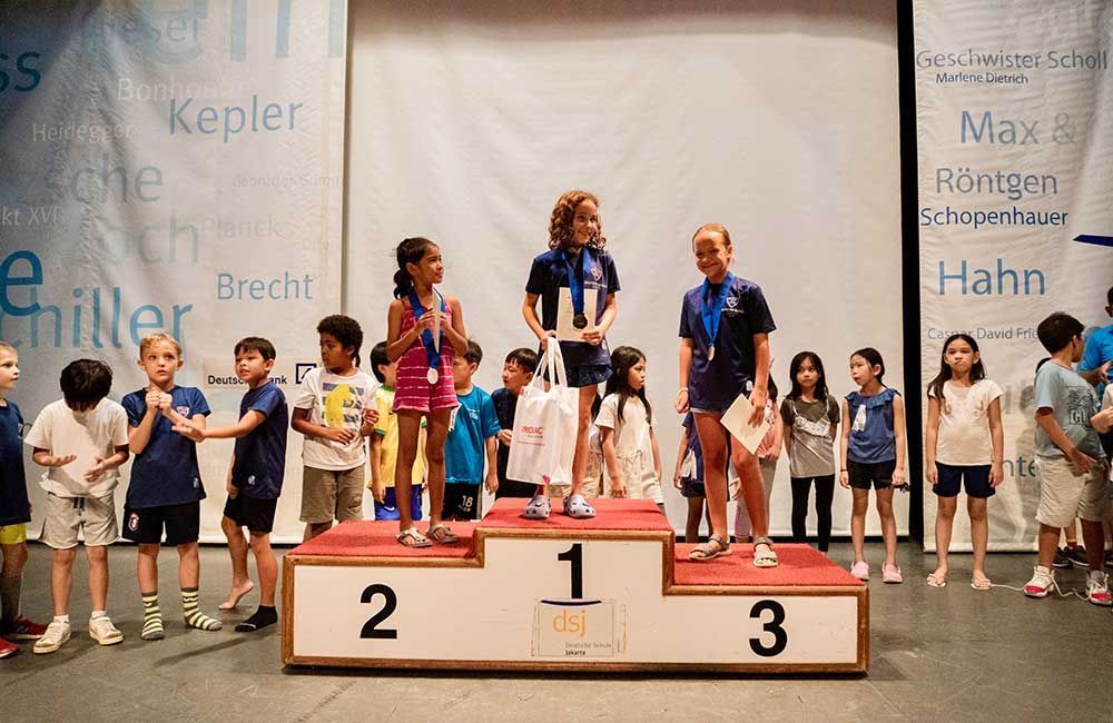 A group of children are standing on a podium.
