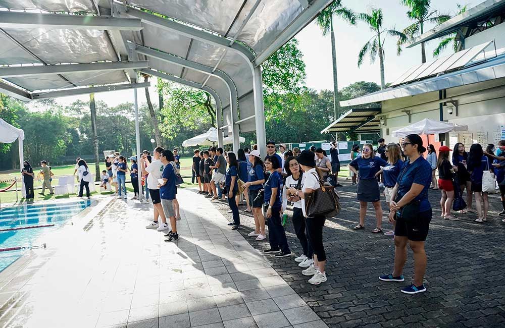 A group of people are standing in a line outside of a building.