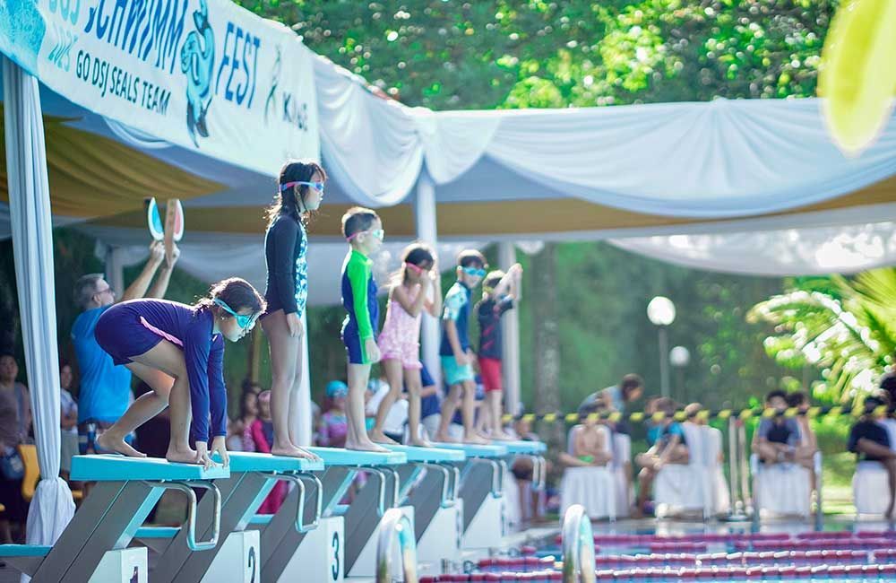 A group of children are getting ready to jump into a swimming pool.