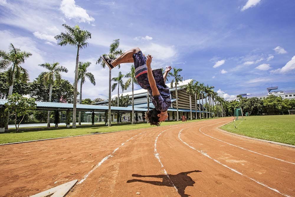 A person is doing a handstand on a track.