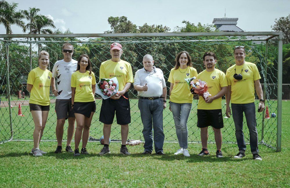 A group of people are posing for a picture in front of a soccer goal.