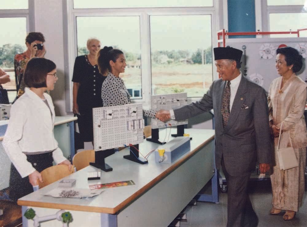 A man in a suit is shaking hands with a woman