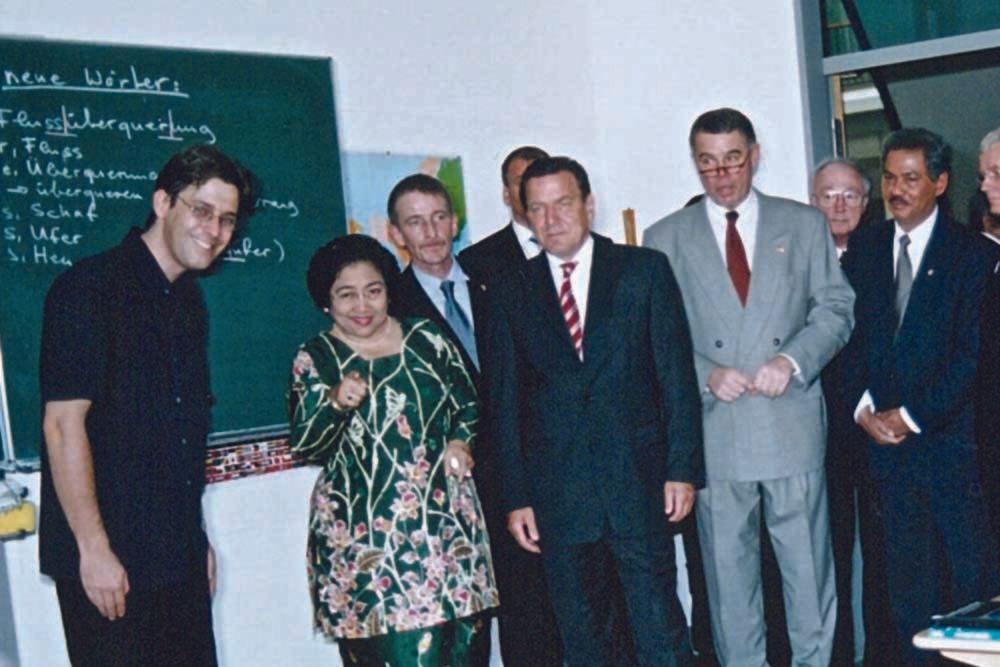 A group of people standing in front of a blackboard that says 