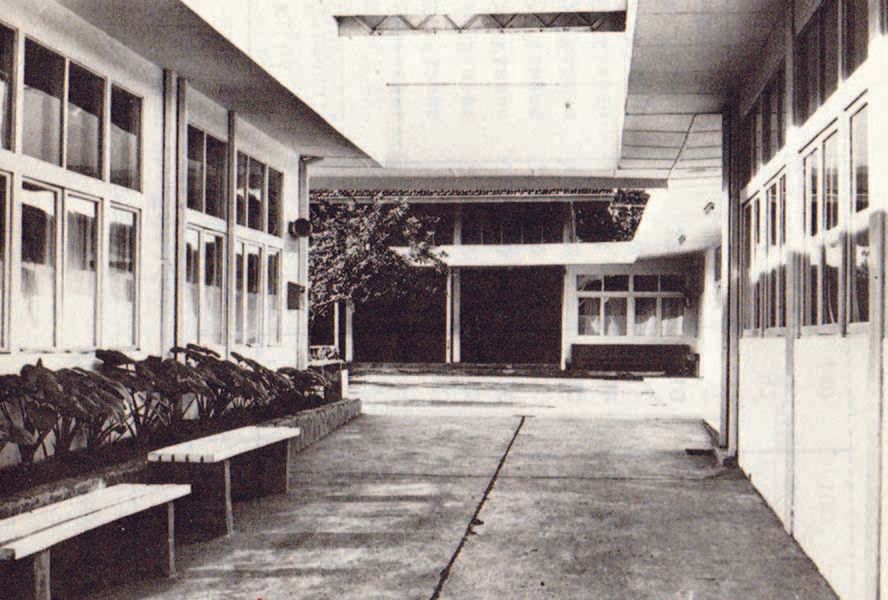 A black and white photo of a hallway between two buildings